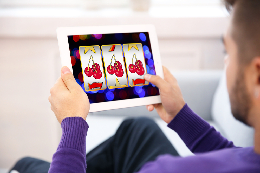 Online Casino in der Schweiz: Gesetzeslage und legale Online-Casinos 1 mann spielt online casino auf tablet